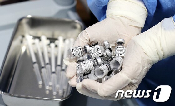 서울의 한 백신접종센터에서 관계자가 사용한 화이자 바이알을 들고 있다. © News1 박지혜 기자