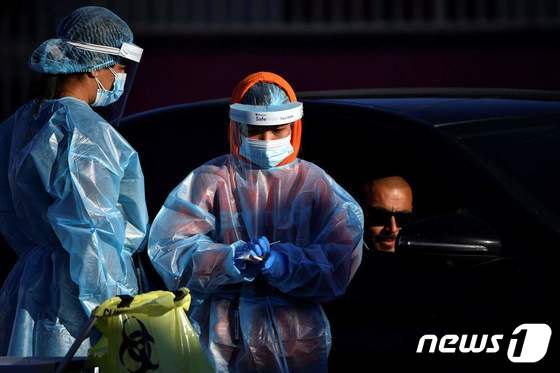 4일 시드니 서부 드라이브스루 코로나19 검사 센터에서 의료진이 운전자의 샘플을 채취하고 있다. © AFP=뉴스1