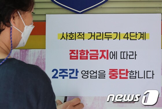 대전 유성구에 위치한 노래방에서 주인이 영업중단을 알리는 안내문을 붙이고 있다. 2021.8.9/뉴스1 © News1 김기태 기자