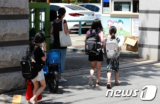 9일 오후 서울의 한 초등학교에서 학생들이 온라인 개학식을 마치고 새학기 교과서를 받기 위해 등교하고 있다. 2021.8.9/뉴스1 © News1 구윤성 기자