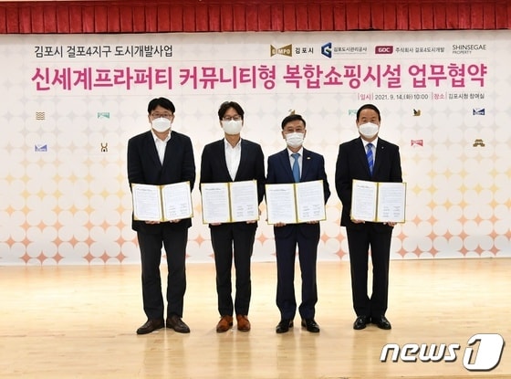 정하영 김포시장(사진 왼쪽에서 세번째)이 업무협약 후 신세계프라퍼티 관계자와 기념사진을 촬영하고 있다. (김포시 제공)© 뉴스1