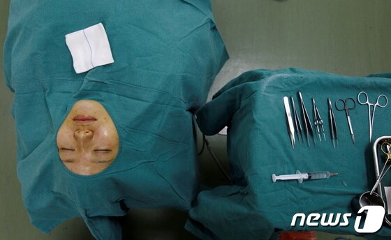 중국 상하이의 한 성형외과에서 쌍꺼풀 수술을 받으려는 환자가 누워서 대기중이다. © 로이터=뉴스1