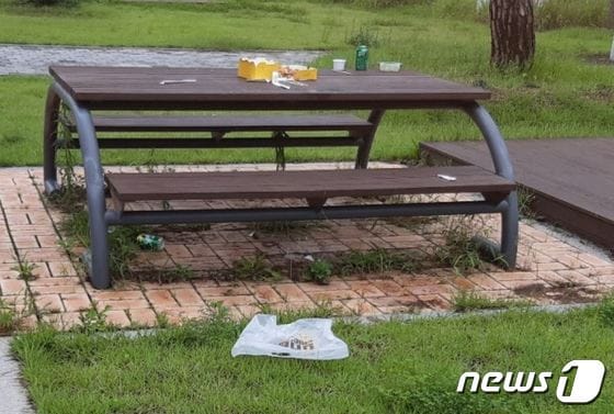 세종시 금강수변공원에 설치된 테이블 위에 먹다 남긴 치킨상자와 맥주캔이 버려져 있다. (독자제공) © 뉴스1
