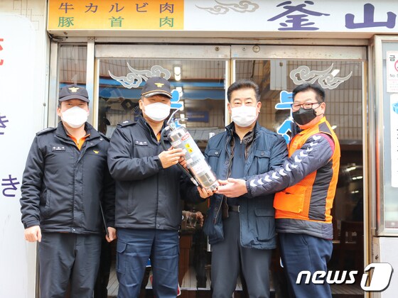 지난 3월5일 부산 의용소방대원들이 중구 일대 음식점에 'K'급 소화기를 전달했다.(부산소방재난본부 제공) © 뉴스1