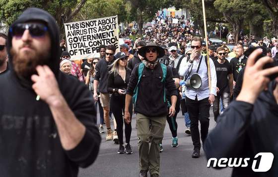 18일 호주 멜버른에서 도시 봉쇄에 반대하는 시위대가 행진하고 있다. © AFP=뉴스1