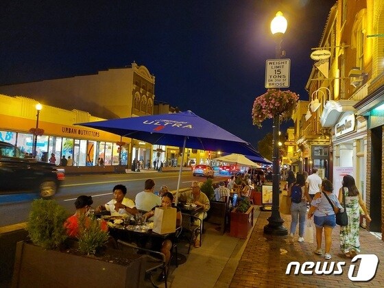 미 워싱턴DC 조지타운에 있는 한 식당의 야외 테이블에서 사람들이 음식을 즐기고 있다. © 뉴스1