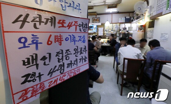 서울 광화문의 한 음식점에서 관계자가 백신 인센티브 관련 문구가 적힌 안내문을 붙이고 있다./뉴스1 © News1 김진환 기자