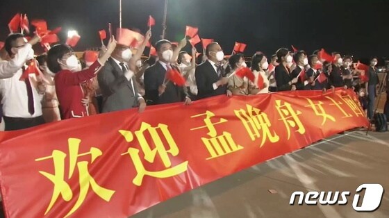 25일 선전 바오안 공항에 많은 인파가 모여 '멍완저우 여사의 귀국을 환영한다'는 현수막을 걸고 그를 환영하고 있다. © 로이터=뉴스1 © News1 박형기 기자