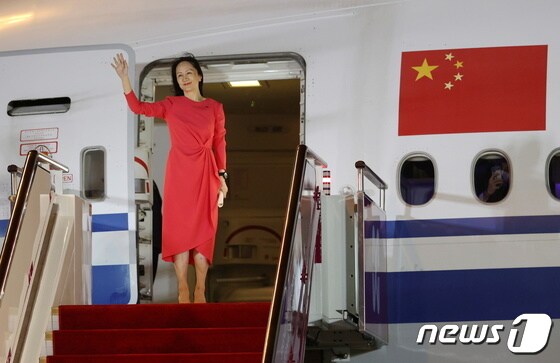25일 선전 바오안 공항에 도착해 환영인파에 손을 흔들고 있는 멍완저우. © 로이터=뉴스1 © News1 박형기 기자