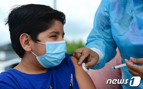 26일(현지시간) 온두라스 테구시갈파에 마련된 코로나19 백신 접종소에서 청소년이 화이자 백신을 맞고 있다. © AFP=뉴스1 © News1 우동명 기자