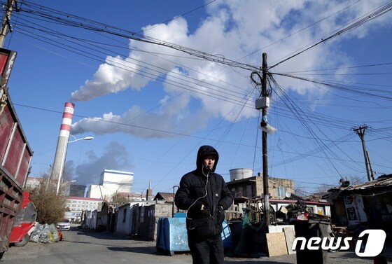 한 시민이 중국 헤이룽장성 하얼빈에 위치한 석탄 화력 발전소 인근을 걸어가고 있다. © 로이터=뉴스1 