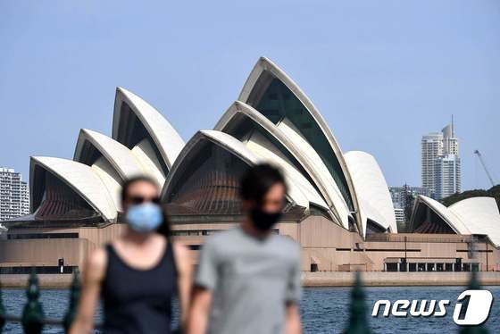 10일(현지시간) 호주 시드니에서 마스크를 쓴 시민들이 오페라하우스 인근 도보를 걷고 있다. 2021.09.10 © AFP=뉴스1
