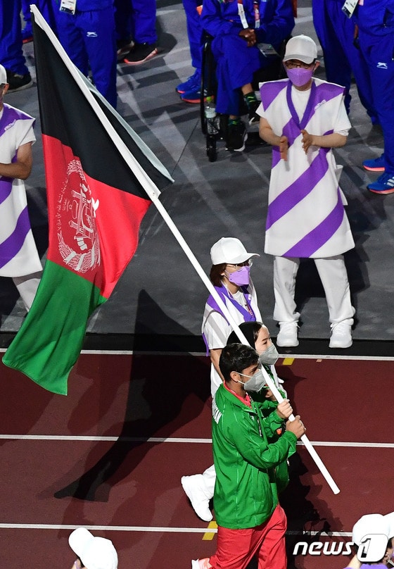 5일 오후 일본 도쿄 올림픽스타디움에서 열린 도쿄패럴림픽 폐회식에서 아프가니스탄 태권도 선수 자키아 쿠다다디와 육상선수 호사인 라소울리가 국기를 들고 입장하고 있다. 2021.9.5/뉴스1 © News1 사진공동취재단
