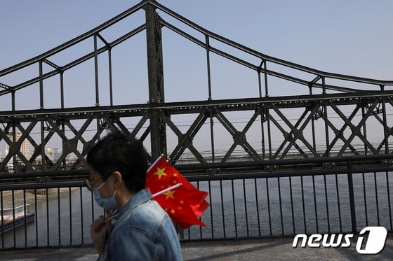 북한 신의주와 중국 단둥을 잇는 압록강철교 옆을 지나는 중국인 관광객. © 로이터=뉴스1
