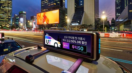 우티(UT)가 모빌리티 어반테크 기업 모토브와 미래 모빌리티 혁신사업을 위한 업무협약(MOU)를 체결했다. 택시 상단 표시등에 부착되는 모토브의 상황 인지형 스마트 광고판 (우티 제공)