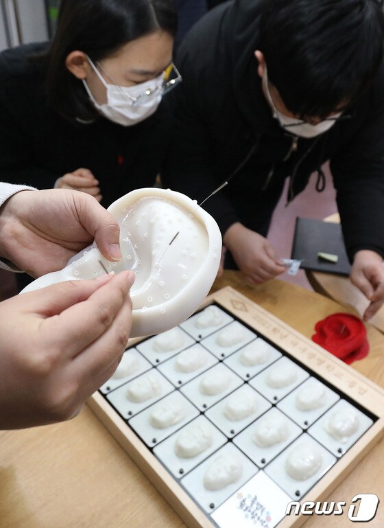 대구콘텐츠센터에 입주한 경북대 크리에이티브팩토리에서 직원들이 3D프린터를 이용해 만든 의료용 교구 가운데 귀 모형 시제품을 확인하고 있다. © 뉴스1