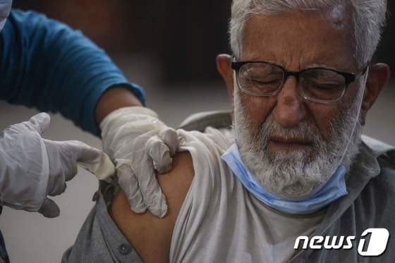 19일 (현지시간) 파키스탄 카라치에 마련된 코로나19 백신 접종소에서 주민이 화이자 백신 부스터샷을 맞고 있다. © AFP=뉴스1 © News1 우동명 기자