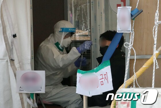 23일 인천시 남동구 중앙공원 임시선별검사소에서 시민이 코로나19 검체 검사를 받고 있다. 2022.1.23/뉴스1 © News1 정진욱 기자
