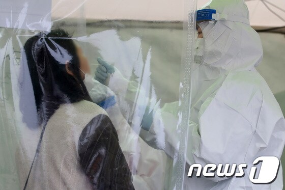 25일 오전 대구스타디움에 마련된 임시선별검사소에서 의료진이 한 시민의 검체를 채취하고 있다. 2022.1.25/뉴스1 © News1 공정식 기자
