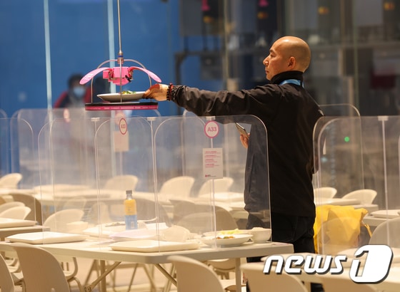 2022 베이징동계올림픽을 4일 앞둔 31일 베이징 메인 미디어 센터(Main Media Centre) 식당에서 코로나19 감염 위험을 줄이기 위해 로봇이 음식을 가져다주고 있다. 2022.1.31/뉴스1 © News1 안은나 기자