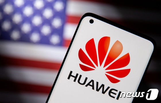 미국 성조기 앞에 화웨이 로고를 띄운 스마트폰이 놓여 있다. © 로이터=뉴스1 © News1 강민경 기자