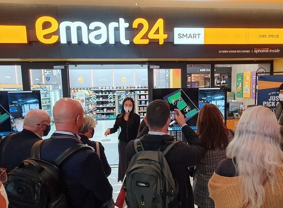 이마트24 스마트코엑스점에 방문한 세계프랜차이즈협의회 회원들이 설명을 듣고 있다.(이마트24 제공)