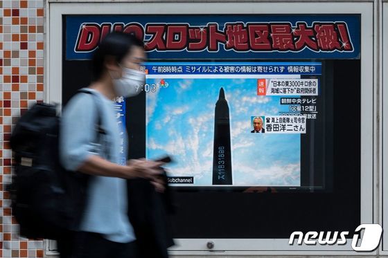 지난 4일 일본 도쿄에서 한 시민이 북한의 미사일 발사 소식을 보도하는 텔레비전 화면 앞을 지나가고 있다. © AFP=뉴스1