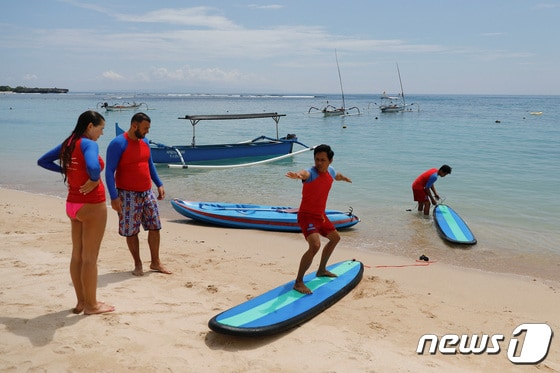 17일(현지시간) 인도네시아 발리 누사 두아 해변에서 관광객들이 서핑 강습을 받고 있다. © 로이터=뉴스1 © News1 정윤영 기자