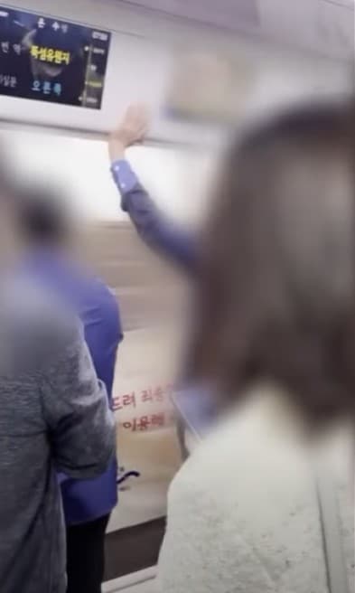 서울지하철 7호선 온수행 열차가 문이 열린 채 뚝섬유원지역으로 향하고 있다. 서울교통공사 직원은 승객을 보호하기 위해 급하게 현수막으로 출입구를 가렸다.  (SBS 갈무리)
