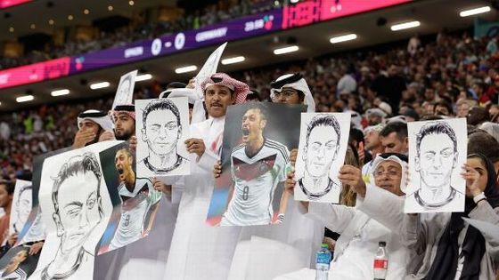 카타르 축구 팬들이 독일과 스페인의 경기에서 메수트 외질의 사진을 들고 독일의 이중성을 비판하는 시위를 하고 있다 (ESPN)