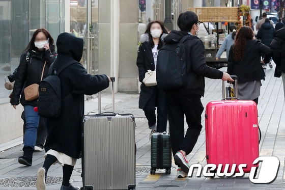 1일 서울 중구 명동에서 외국인 관광객들이 여행용 가방을 끌고 거리를 지나고 있다.2022.12.1/뉴스1 © News1 민경석 기자
