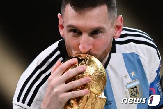 아르헨티나의 리오넬 메시가 18일 (현지시간) 카타르 루사일 스타디움에서 열린 2022 카타르 월드컵 결승전에서 프랑스를 꺾고 36년만에 정상에 오른 뒤 월드컵에 입을 맞추고 있다. © AFP=뉴스1 © News1