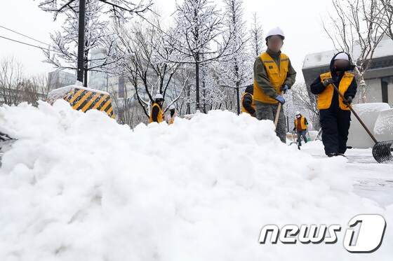서울 광화문 광장에서 중부공원여가센터 관계자들이 쌓인 눈을 치우고 있다. 2022.12.21/뉴스1 © News1 조태형 기자