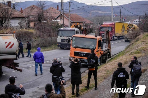 29일(현지시간) 코소보 북부 미트로비차시 인근 루다레 지역에 세르비아계 주민들이 도로 한 가운데 주차한 트럭들을 철수하고 있다. 2022.12.29/뉴스1 © AFP=뉴스1 © News1 김민수 기자
