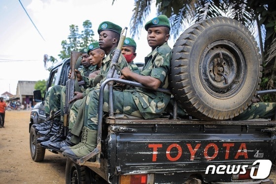 3일(현지시간) 콩고민주공화국 베니에서 총을 들고 있는 군인들이 차량 뒤쪽에 앉아 이동하고 있다. 2022.12.03 © AFP=뉴스1 © News1 정윤미 기자