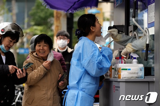7일 중국 상하이의 핵산 검사소에서 한 여성이 PCR 검사를 받고 있다. 2022.12.07/뉴스1 © 로이터=뉴스1 © News1 김민수 기자