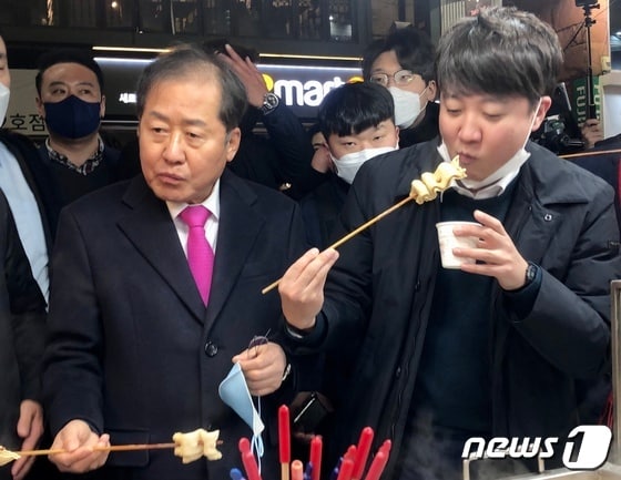 홍준표 국민의힘 의원과 이준석 당 대표가 지난 2월 12일 오후 대구 동성로 어묵가게에서 어묵을 먹고 있는 모습. © News1 