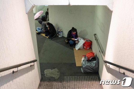 홍콩의 외국인 노동자들이 마스크를 쓴 채 실외에서 휴식을 취하고 있다. © AFP=뉴스1