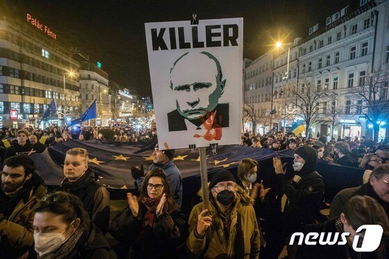친우크라이나 시위대가 22일(현지시간) 체코 프라하 벤세슬라스 광장에서 우크라이나를 지지하는 시위 도중 푸틴 대통령의 얼굴이 새겨진 플래카드를 보여주고 있다. 블라디미르 푸틴 러시아 대통령은 전날 우크라이나 동부 지역 친러 분리주의자들이 결성한 도네츠크인민공화국(DPR)과 루간스크인민공화국(LPR)의 독립을 승인하고 평화유지를 명분으로 자국군에 이 지역 진입을 명령했다. © AFP=뉴스1