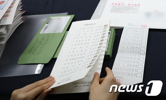 서울 용산구선거관리위원회에서 관계자가 시각장애인을 위해 제작된 점자형 투표보조용구에 투표용지를 끼우고 있다. 2022.2.26/뉴스1 © News1 허경 기자