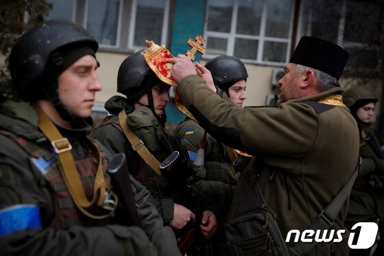13일 (현지시간) 우크라이나 수도 키이우에서 러시아 군과 전투에 나서는 장병들에게 사제가 축원을 하고 있다. © 로이터=뉴스1 © News1 우동명 기자