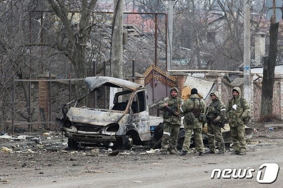 15일(현지시간) 우크라이나 도네츠크의 볼노바하에서 우크라이나 군과 러시아 군의 전투 중 친러시아 반군이 파괴된 차량 옆에 모여 있다. © 로이터=뉴스1 © News1 우동명 기자