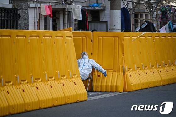 코로나 봉쇄령이 내려진 중국 상하이에서 보호복을 입은 방역요원이 출입을 통제하고 있다. © AFP=뉴스1 © News1 우동명 