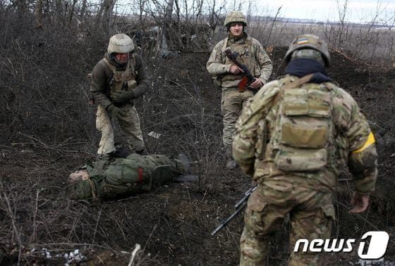 6일 우크라 루간스크 지방에서 러시아 군, 친러시아 반군과 전투를 치른 우크라이나 군이 전사자를 살펴보고 있다. © AFP=뉴스1 © News1 우동명 기자
