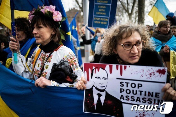 6일(현지시간) 프랑스 남부 툴루즈에서 우크라이나 전쟁 반대 시위에 참가한 한 여성이 '푸틴 암살 멈춰'라고 적힌 피켓을 들고 있다. © AFP=뉴스1 © News1 정윤미 기자