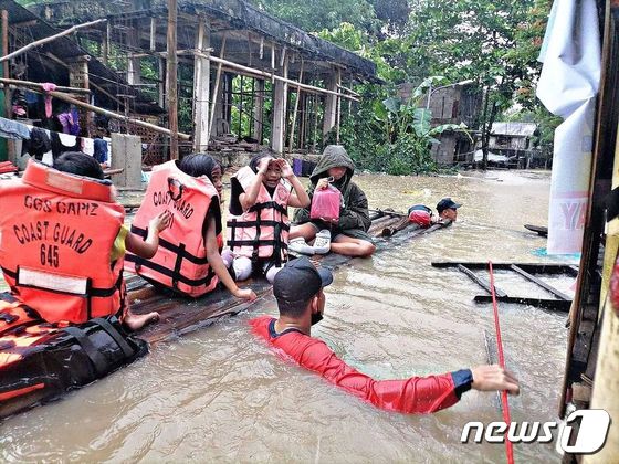 2022년 태풍 ‘메기’ 강타로 폭우가 쏟아진 필리핀 파니탄에서 구조대원들이 주민을 대피시키고 있다. © AFP=뉴스1 © News1 우동명 기자