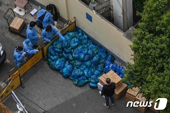 지난 16일  코로나19 봉쇄령이 내려진 중국 상하이에서 방역요원들이 주민들에게 배급할 먹거리를 분류하고 있다. © AFP=뉴스1 © News1 우동명 기자