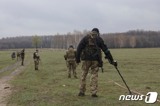 21일 (현지시간) 우크라이나 수도 키이우에서 병사들이 러시아 군의 불발 폭탄과 지뢰를 탐지하고 있다. © 로이터=뉴스1 © News1 우동명 기자