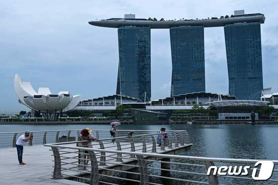 싱가포르에 코로나19 방역규제가 대부분 해제된 26일 랜드마크 마리나베이샌즈 호텔이 보이는 공원에서 여유를 즐기는 시민들의 모습. © AFP=뉴스1 © News1 최서윤 기자