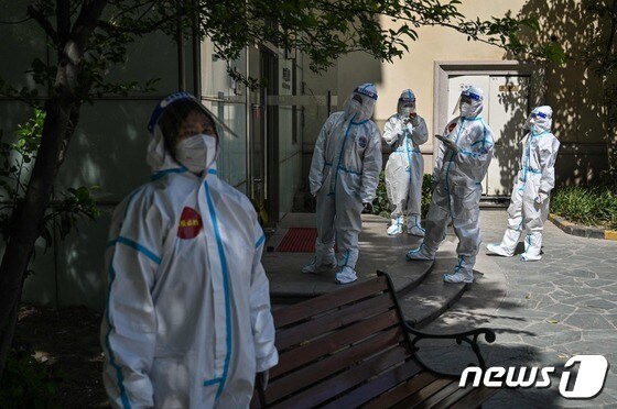 4일 도시 봉쇄가 영장된 중국 상하이의 한 아파트 앞에 보호장구를 착용한 의료진과 자원봉사자가 도착했다. © AFP=뉴스1